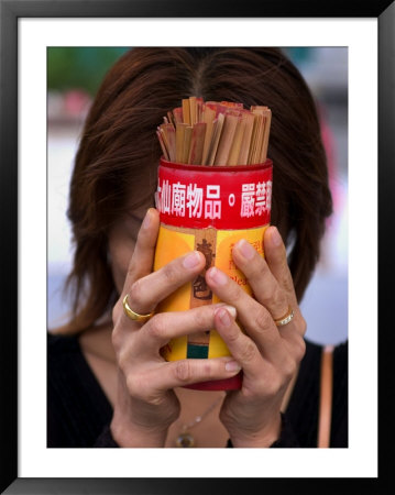 Woman Holding Prayer Sticks At Wong Tai Sin Temple, Kowloon, China by Michael Coyne Pricing Limited Edition Print image