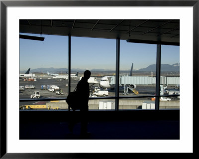 A Silhouette Walks Past A Window Looking Out At The Tarmac, Vancouver, British Columbia, Canada by Taylor S. Kennedy Pricing Limited Edition Print image