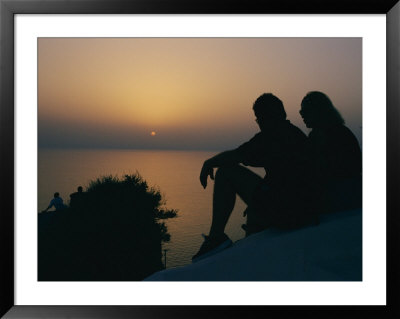 Silhouette Of A Couple Watching The Sunset Over The Aegean Sea by Todd Gipstein Pricing Limited Edition Print image