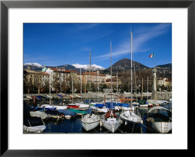 Yachts In Harbour At Intra With Old Town And Mountains In Background, Lago Maggiore, Italy by Martin Moos Pricing Limited Edition Print image