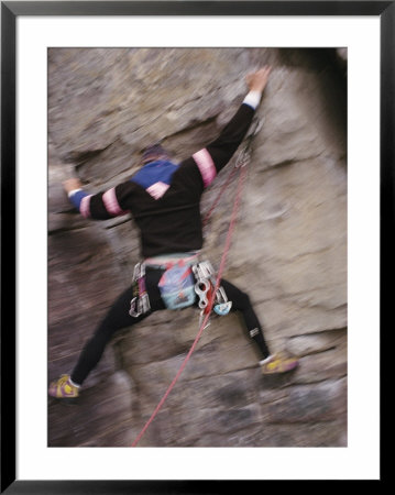 A Rock Climber Clings To The Side Of A Cliff by Raymond Gehman Pricing Limited Edition Print image