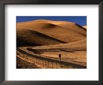Person Jogging Along Road Through Hills, Usa by Nicholas Pavloff Pricing Limited Edition Print image