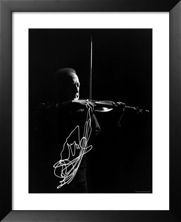 Violinist Jascha Heifetz Playing In Mili's Darkened Studio As Lit Bow Traces Bow Movement by Gjon Mili Pricing Limited Edition Print image