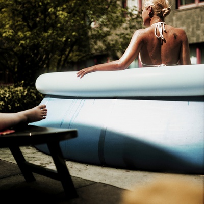 A Young Woman Sitting In An Inflatable Swimming Pool by Jewgeni Roppel Pricing Limited Edition Print image