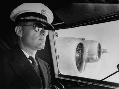 A Pilot Wearing His Sunglasses While Flying Aboard The Atlantic Clipper by Bernard Hoffman Pricing Limited Edition Print image