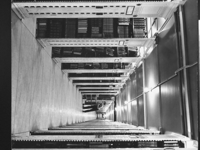 Man Pushing Cart Into Row In The Top Stack In New York Public Library by Alfred Eisenstaedt Pricing Limited Edition Print image