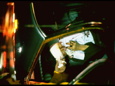 Bloodied Car Accident Victim Being Handed Bandages In Car by Ralph Crane Pricing Limited Edition Print image