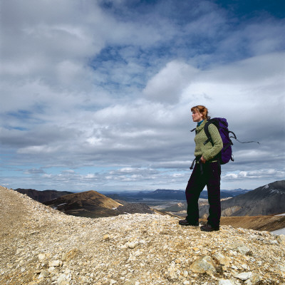 A Woman Hiking In The Highlands Of Iceland, Carrying A Backpack by Thorsten Henn Pricing Limited Edition Print image