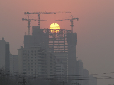 Sun Sets Behind Cranes During Construction Of New Polly Plaza At Dongsishitiao In Central Beijing by Ben Mcmillan Pricing Limited Edition Print image