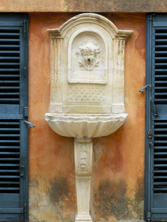 Small Stone Fountain On Villa Wall And Blue Shutters, La Casella, France, Garden By Claus Scheinert by Clive Nichols Pricing Limited Edition Print image