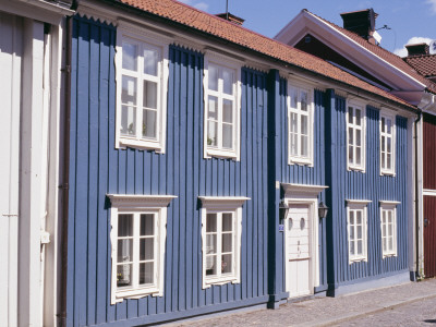 Row Of Colourful Homes (Blue, Red) On Street, Traditional Style With Timber Cladding by Andy Keate Pricing Limited Edition Print image