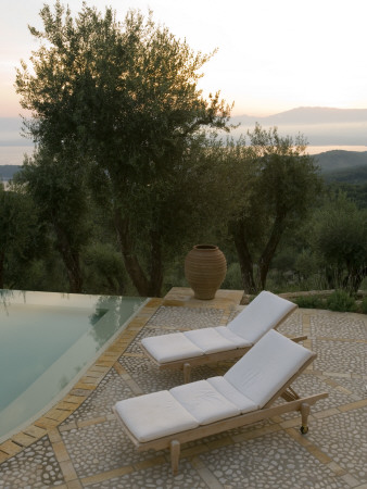 Sun Loungers And Pot On Terrace Beside Infinity Pool At Dusk, Corfu by Clive Nichols Pricing Limited Edition Print image