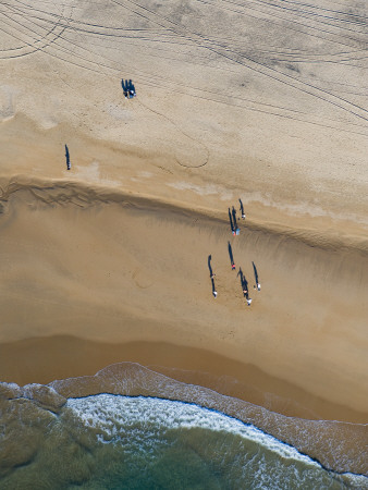 People On A Beach With Very Long Shadows, Near Cadiz, Spain, February 2008 by Niall Benvie Pricing Limited Edition Print image