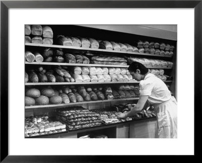 Good Of Worker In Bakery Standing In Front Of Shelves Of Various Kinds Of Breads And Rolls by Alfred Eisenstaedt Pricing Limited Edition Print image