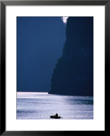 Woman Navigates Among Magnificent Limestone Islands Of Halong Bay, Halong Bay, Quang Ninh, Vietnam by Stu Smucker Pricing Limited Edition Print image