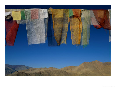 A Line Of Multi-Colored Prayer Flags Sway In The Gentle Breeze In Ladakh by Barry Tessman Pricing Limited Edition Print image
