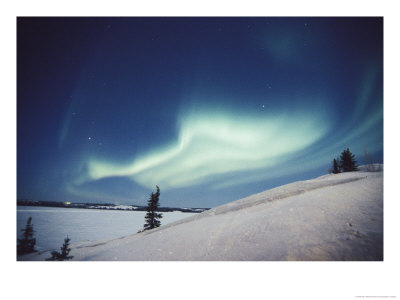 The Aurora Borealis Creates A Fantastic Swirl Of Light Over The Snowy Landscape by Paul Nicklen Pricing Limited Edition Print image