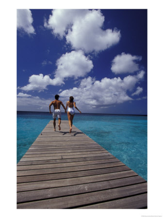 Couple Running On Dock, Curacao, Caribbean by Greg Johnston Pricing Limited Edition Print image