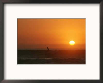 A Man Surfs As The Sun Sets On The Pacific Ocean, Baja, Mexico by Jimmy Chin Pricing Limited Edition Print image