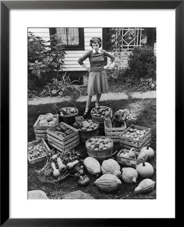 Woman Looking At Victory Garden Harvest Sitting On Lawn, Waiting To Be Stored Away For Winter by Walter Sanders Pricing Limited Edition Print image