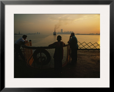 Riders On The Staten Island Ferry Look Out At The Manhattan Skyline by Maria Stenzel Pricing Limited Edition Print image