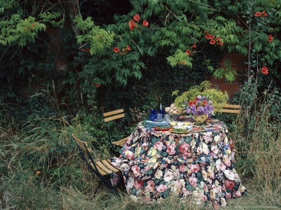 Chairs And A Table With A Floral Cloth And Salad Dishes Outside Amongst Long Grass Alfresco by Linda Burgess Pricing Limited Edition Print image