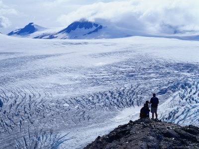 Hikers Looking Over Exit Glacier And Harding Ice Field, Kenai Fjords National Park, Usa by Brent Winebrenner Pricing Limited Edition Print image