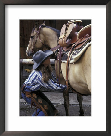 Female Wrangler Saddles Horse At Boulder River Ranch, Montana, Usa by John & Lisa Merrill Pricing Limited Edition Print image