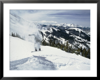 A Snowboarder Makes His Way Downhill Leaving A Puff Of Airborne Snow Behind Him by Paul Chesley Pricing Limited Edition Print image