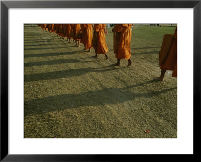 A Group Of Buddhist Monks Walk Single-File Down A Dirt Road by Jodi Cobb Pricing Limited Edition Print image