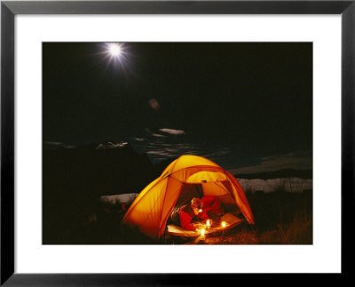 Man Reading In A Tent At Night With Cerro Victoria In The Distance by Gordon Wiltsie Pricing Limited Edition Print image