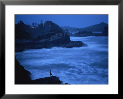 A Silhouetted Person Stands On The Rocky Coast As Night Falls by Joel Sartore Pricing Limited Edition Print image