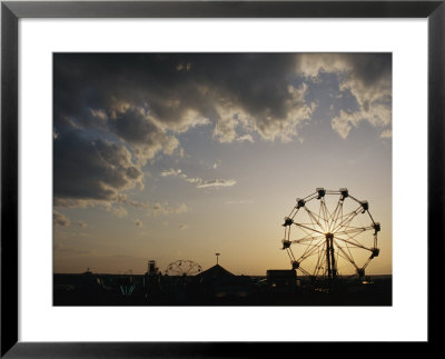 A Ferris Wheel Is Silhouetted Against The Evening Sky by Stephen Alvarez Pricing Limited Edition Print image