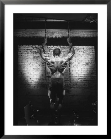 Rear View Of Muscular Man Holding Chains by Dennis Lane Pricing Limited Edition Print image