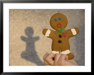 A Gingerbread Cookie Looks Scared While Being Held In A Boy's Hand by Joel Sartore Pricing Limited Edition Print image