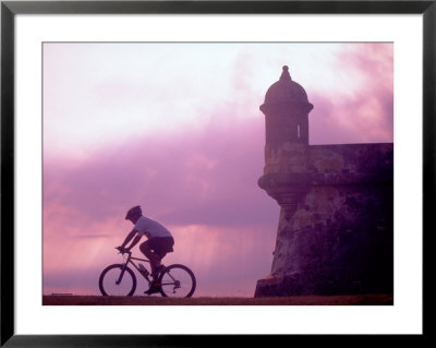 Cycling At El Morro In Old San Juan At Sunset, Puerto Rico by Greg Johnston Pricing Limited Edition Print image
