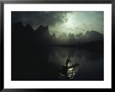 A Fisherman Poles His Raft Past Karst Formations On The Li River by James P. Blair Pricing Limited Edition Print image