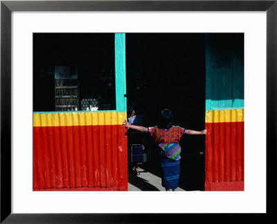 Girl Standing In Market Doorway, Santa Maria De Jesus, Guatemala by Jeffrey Becom Pricing Limited Edition Print image