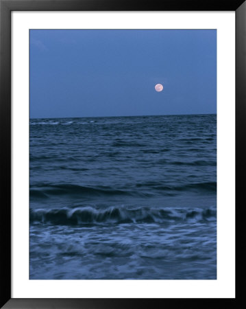 A Twilight Shot Of Waves Coming Into Shore With The Moon In The Background by Ira Block Pricing Limited Edition Print image