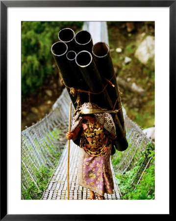 A Women Carrying A Heavy Load Across A Bridge, Kalopani, Annapurna Circuit, Nepal by Andrew Parkinson Pricing Limited Edition Print image