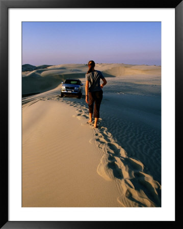Woman Walking Towards Car On Sand Dune Ridge, Khor Al-Adaid, Qatar by Mark Daffey Pricing Limited Edition Print image