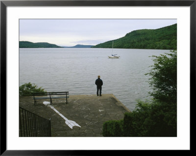 A Man Looks Out At A Sailboat Anchored On Otsego Lake by Raymond Gehman Pricing Limited Edition Print image
