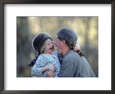 A Father And His Daughter Laugh Together While Wearing Coonskin Hats by Joel Sartore Pricing Limited Edition Print image
