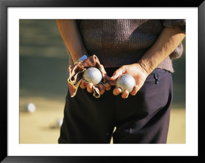 A Man Holding Two Balls Waiting His Turn To Play Bocci by Michael Melford Pricing Limited Edition Print image