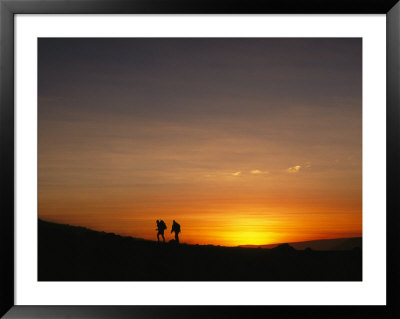 Expedition Members Hike Into Base Camp Silhouetted Against A High-Altitude Sunset by Stephen Alvarez Pricing Limited Edition Print image