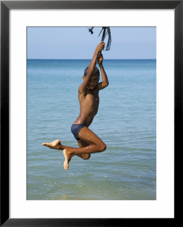 Boy Swinging From Rope Over Sea, Little Corn Island, Corn Islands, Atlantico Sur, Nicaragua by Margie Politzer Pricing Limited Edition Print image