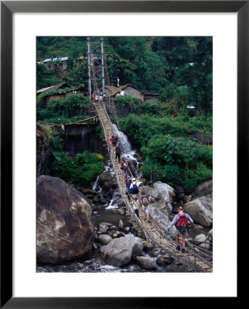 People Crossing Sagging Suspension Bridge Over Khudi Khola On Annapurna Circuit, Nepal by Tony Wheeler Pricing Limited Edition Print image