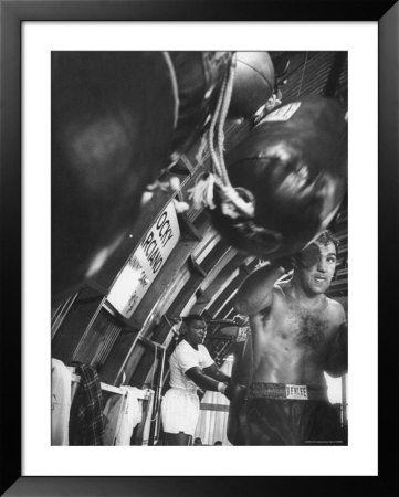Boxer Rocky Marciano, Working Out Punching Bag, At Training Camp, Before Fight With Archie Moore by Grey Villet Pricing Limited Edition Print image