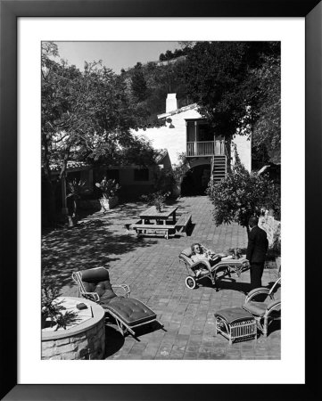 Actress Bette Davis Being Wheeled In A Sun Chair By Her Chauffeur Across The Patio Of Her Home by Alfred Eisenstaedt Pricing Limited Edition Print image
