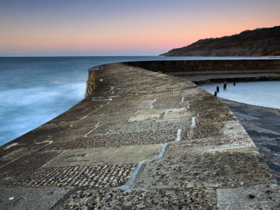 Dawn On Stone Walls Of Cobb, Lyme Regis, Dorset, England. Jurassic Coast World Heritage Site by Adam Burton Pricing Limited Edition Print image